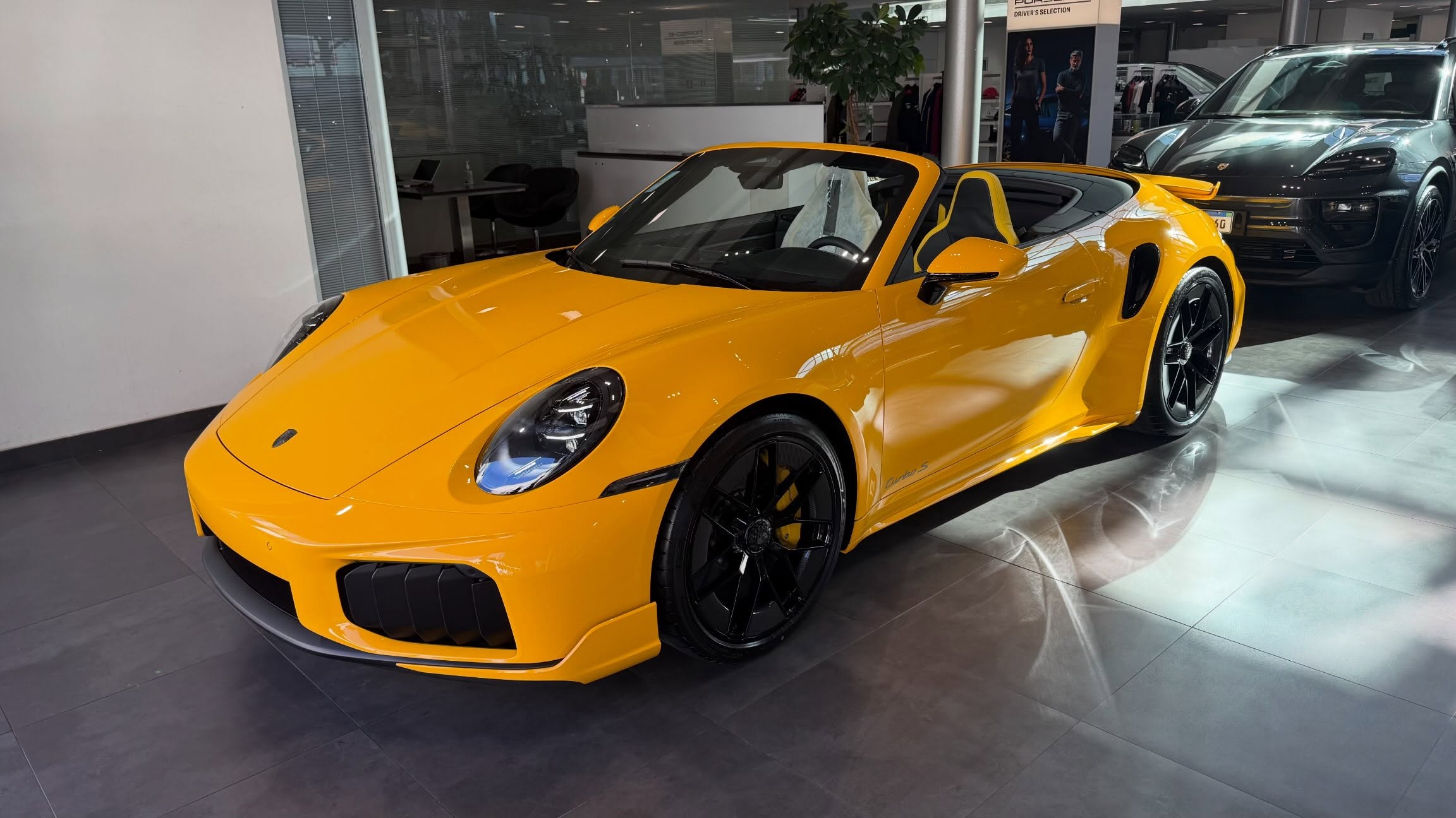 Porsche amarelo fotografado no showroom Collection